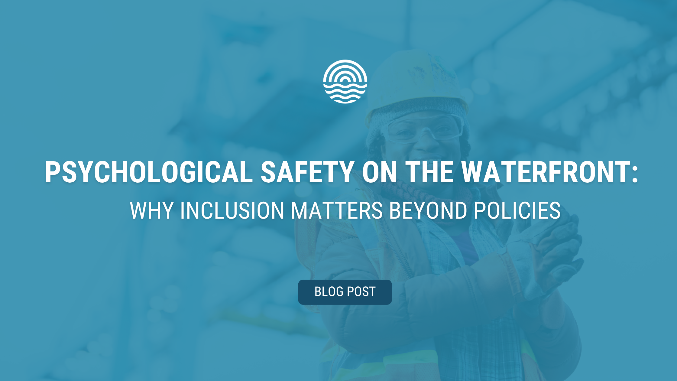 Banner image for a blog post titled “Psychological Safety on the Waterfront: Why Inclusion Matters Beyond Policies.” A blue overlay covers a photo of a smiling worker wearing a hard hat, safety glasses, gloves, and a high-visibility vest in an industrial waterfront setting. The title appears in large white text across the center, with a “Blog Post” label below.